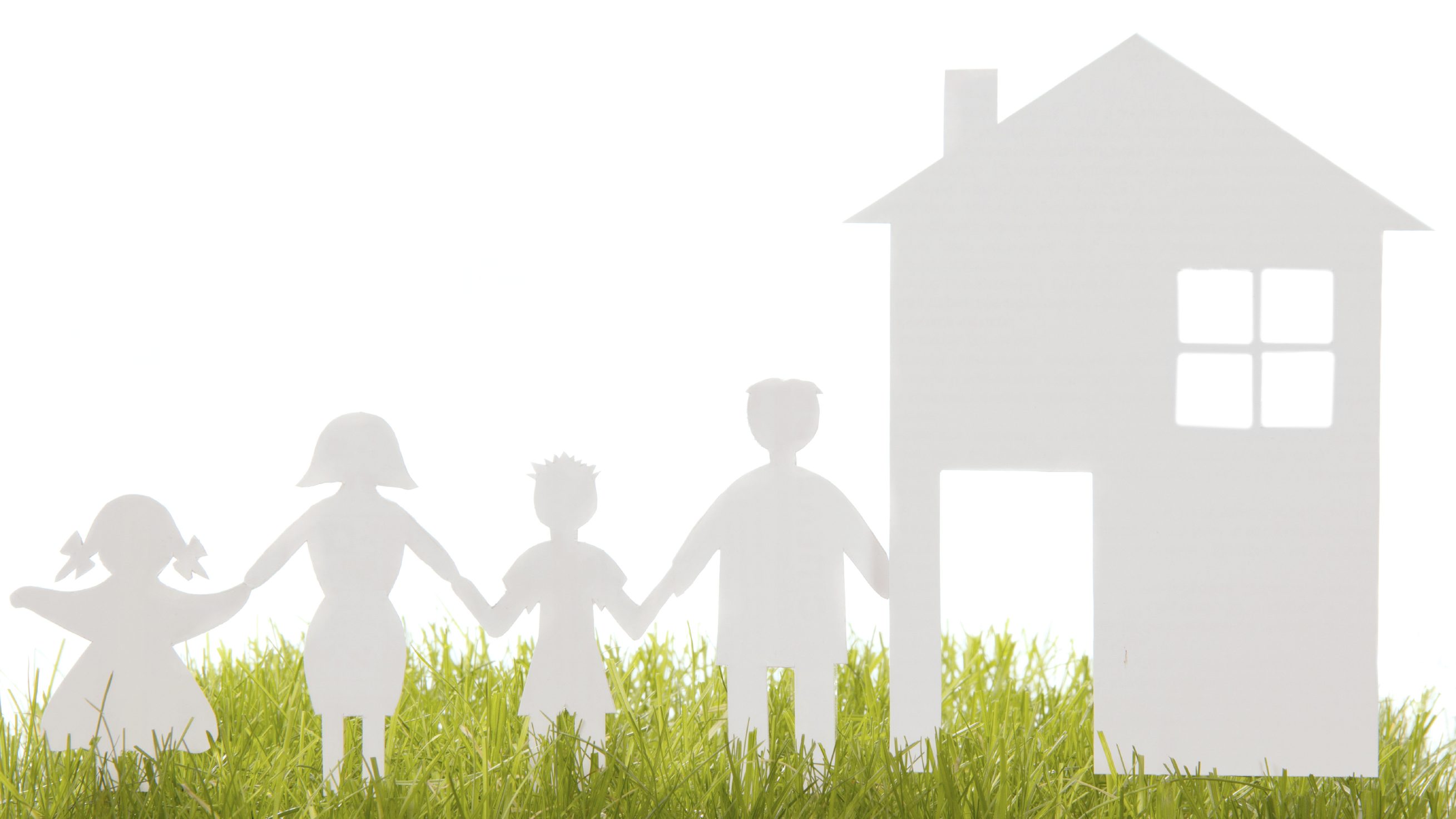 Home and family from paper on the grass isolated on white